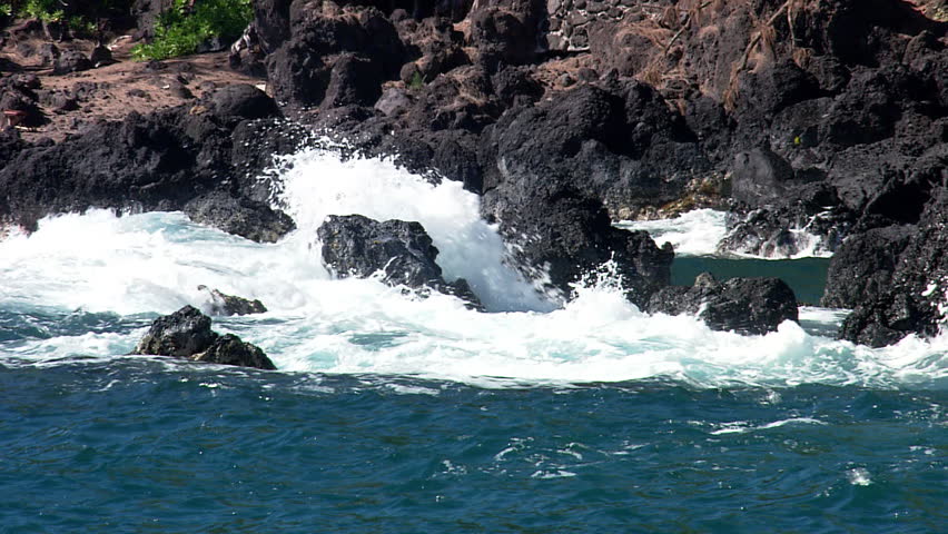 Waves crash in to rocks on the coast of Hawaii's cliffs