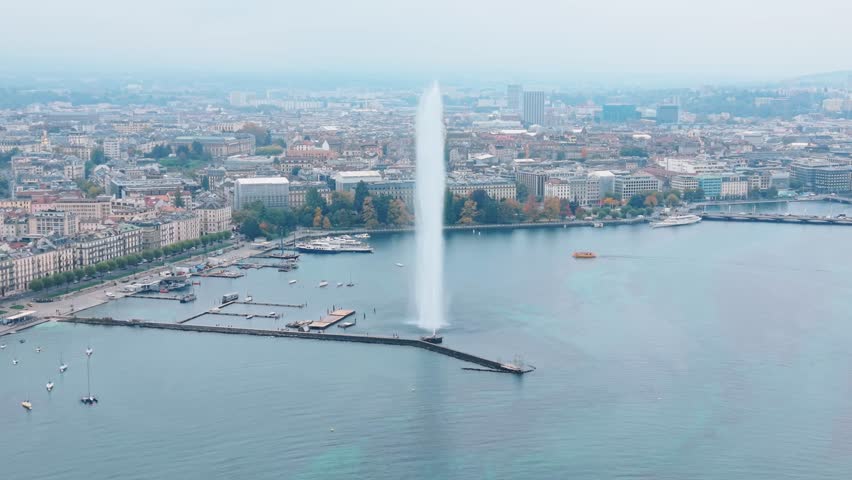 Aerial view of the powerful Jet d'Eau shooting skyward, contrasts beautifully with the calm lake waters and the cityscape, Jet d'Eau de Genève, Geneva, Switzerland.