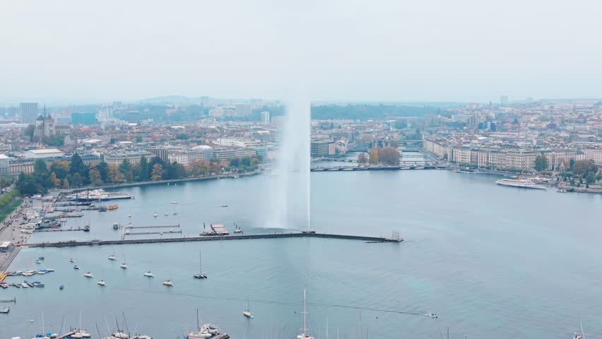 Aerial view of the Jet d'Eau de Genève, a tall water fountain on Lake Geneva with boats and buildings, Quai Gustave-Ador, Geneva, Switzerland.