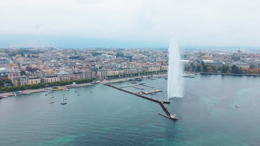 Aerial view of Jet d'Eau de Genève shooting a tall stream of water into the sky as boats are seen in the turquoise water, Geneva, Switzerland.