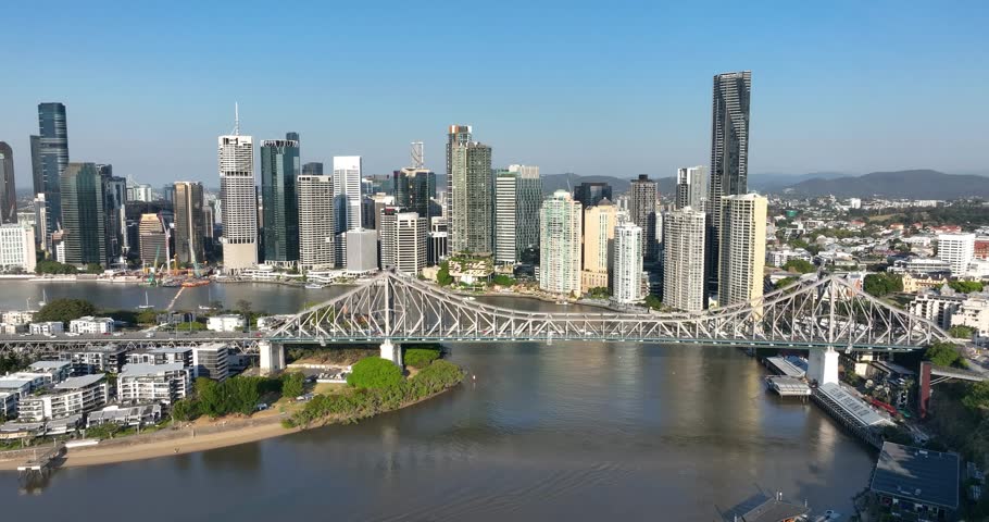 4K aerial right to left pan tracking view of the iconic Story Bridge and east side of Brisbane CBD with the Brisbane River below where CityCat ferries commute passengers,Brisbane,Queensland, Australia