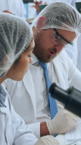 Scientist, medical team and research with documents for clinical trial, study or assessment in lab. Man, woman or people with paperwork or microscope for forensic analysis, report or exam results