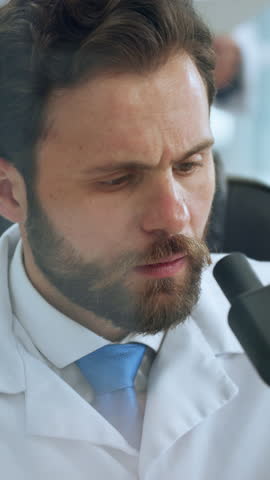 Scientist, man and microscope in lab with inspection for sample analysis, biotech and stem cell research. Bokeh, person and equipment with science, medical innovation and cure development for cancer.