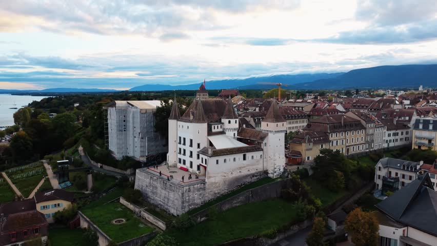 Aerial view of Nyon Castle, standing majestically with its white walls and towers amidst a backdrop of Lake Geneva, Nyon, Vaud, Switzerland.
