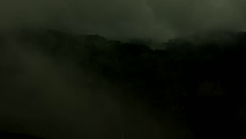 “Dramatic cloud formations moving over lush green mountains during daytime at Lonavala, Maharashtra, India. Scenic misty valleys with waterfalls, fog-covered hills, and a serene lake create a breathta