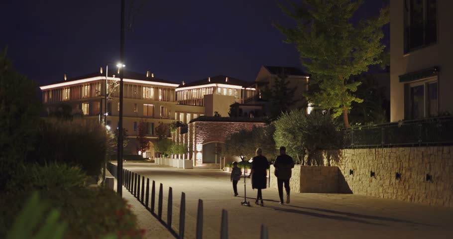 people walk modern Portonovi resort streets at night. Montenegro