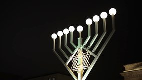 Menorah Candles, Festival Lights, Hanukkah Night. Under night sky, menorah shines with its Hanukkah lights. - Powered by Shutterstock - Get 15% off with code: PIKWIZARD15