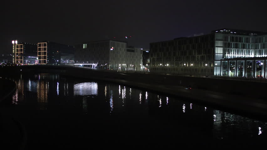Evening glow, Berlin skyline, Urban Berlin. River in Berlin captures radiant facades modern buildings at night.