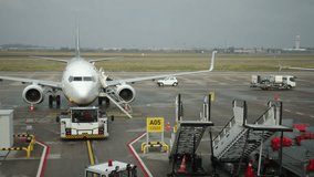 Static plane, Plane tarmac, Ground loading. Cloudy weather surrounds parked airplane at airport gate with ground support and equipment. - Powered by Shutterstock - Get 15% off with code: PIKWIZARD15