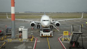 Plane on runway, Ground equipment, Passenger access. Passengers are boarding airplane on tarmac using mobile staircase, with ground support equipment and staff all around. - Powered by Shutterstock - Get 15% off with code: PIKWIZARD15