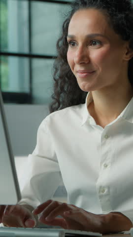 Confident Hispanic business woman typing computer in office smiling happy female businesswoman girl professional manager working positive at workplace satisfied internet browsing website job done