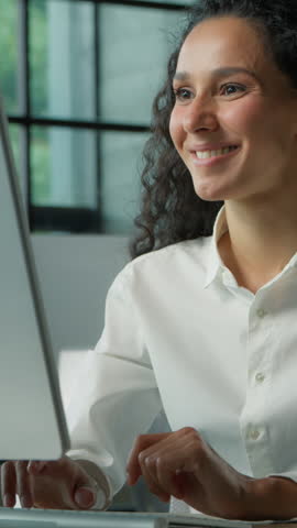 Confident Hispanic business woman typing computer in office smiling happy female businesswoman girl professional manager working positive at workplace satisfied internet browsing website job done