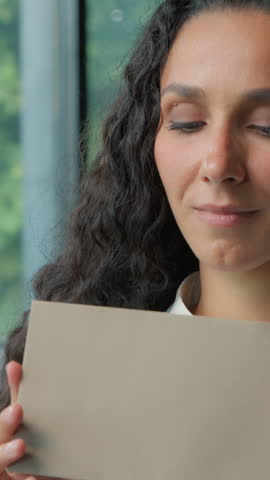Hispanic business woman opening paper envelope reading good news amazed rejoice letter Arabian ethnic businesswoman female girl read information happy yelling joyful invitation bank credit approval