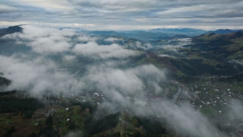 Aerial View of Serene Mountainous Landscape with Mist and Clouds