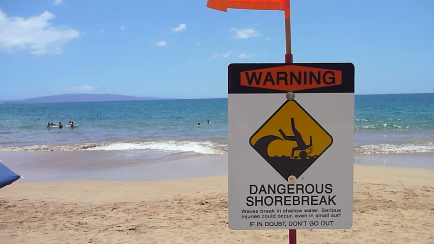 Dangerous shore break sign posted at beach in Hawaii on Maui.