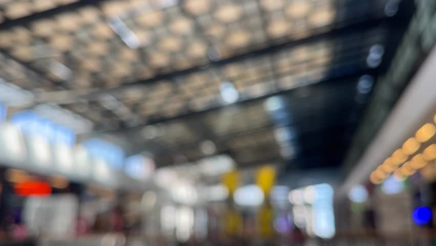 4K Blurred video of Elegant, spacious shopping mall interior, with a long hallway, Colorful light and gold tones, and shops. Gentle bokeh effect