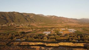 A dramatic sunset over a still lake and surrounding fields, captured with a breathtaking 4K drone shot, highlighting the warm, intense colors of the sky and the dark silhouettes below. - Powered by Shutterstock - Get 15% off with code: PIKWIZARD15