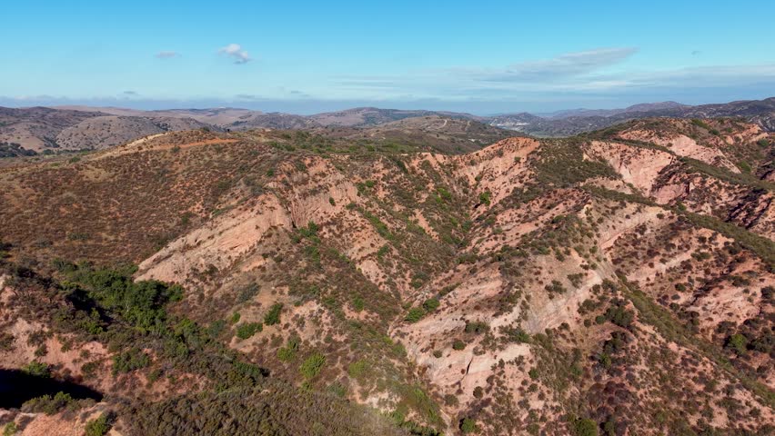 Aerial footage of Black Star Canyon in California reveals steep cliffs, dry vegetation, and sunlit rock formations from a drone’s high vantage point