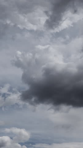 Animated clip of dynamic and professional presentation of various US tax forms, including Form 1040, W-2, W-9, 5498, and 1099-NEC, with prominent 2025 year indicators. The forms elegantly flow, overlap, and rotate across the screen, creating a compelling visual narrative. Ominous storm clouds background highlights the documents, representing trepidation and fear of negative outcomes. This visual effect is perfect for enhancing financial news segments, tax preparation service advertisements, corporate presentations, educational videos on tax regulations, or any content requiring a clean and informative representation of financial documentation for the current tax season. Vertical video format for social media.