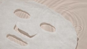 Disposable fabric beauty face mask underwater on a beige background. Concept of face mask supports skincare routines for rejuvenation and detoxification. - Powered by Shutterstock - Get 15% off with code: PIKWIZARD15