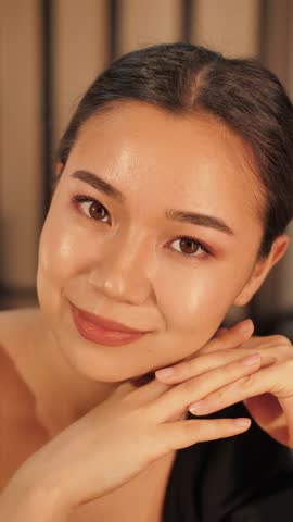 A beautiful woman poses and takes a selfie in front of a mirror after applying makeup. Stylish and confident look, perfect for beauty, lifestyle, fashion, and social media content