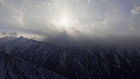 Evening misty mountain landscape with sun halo and snowfall. Drone view with forward movement. - Powered by Shutterstock - Get 15% off with code: PIKWIZARD15