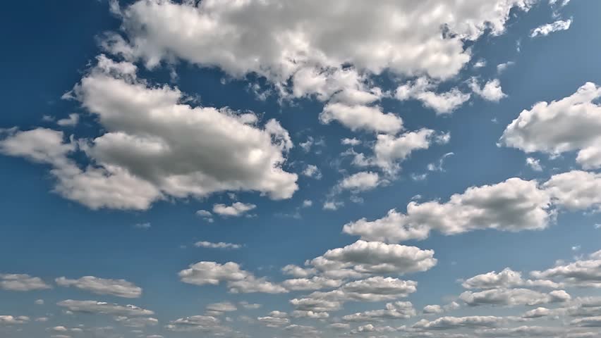 Stunning endless clouds flight forward in the blue skies. 4K video (Ultra High Definition) of cloudscape and bright sun. Sky and clouds Timelapse. Sun shines through the clouds on the blue sky backgro