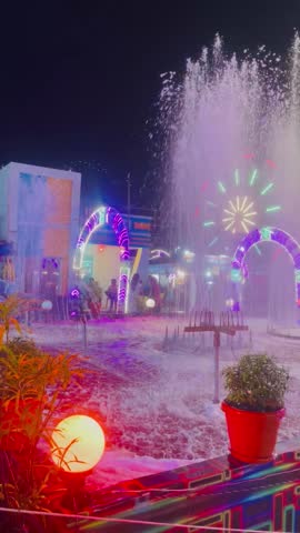 At night at the fair. The New Year and Christmas fairs at night in the colorful lights of the festival. The fair has a beautiful view of the lights and water fountains at night.