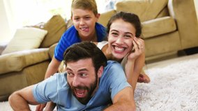 Upon son climbing onto parents' backs family laughing for playful bonding with rotating tech ring. Family, bonding, playfulness, joy, warmth, interaction, holographic - Powered by Shutterstock - Get 15% off with code: PIKWIZARD15