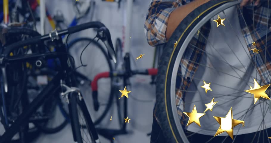 Mechanic grabbing wheel rim in repair shop inspecting spokes for damage with animated gold stars. Mechanic, craftsmanship, industrial, engineering, repair, innovation, professionalism