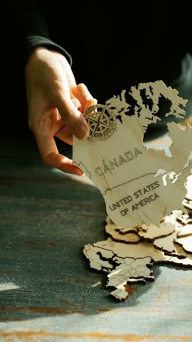 Woman assembling wooden world map puzzle. Global travel planning activity. World map concept.