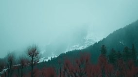 4K shot of winter landscape with snow mountains and forest covered in dark clouds at Betab Valley, Jammu and Kashmir, India. Nature background. Foggy, misty mountains during stormy weather in Himalaya - Powered by Shutterstock - Get 15% off with code: PIKWIZARD15