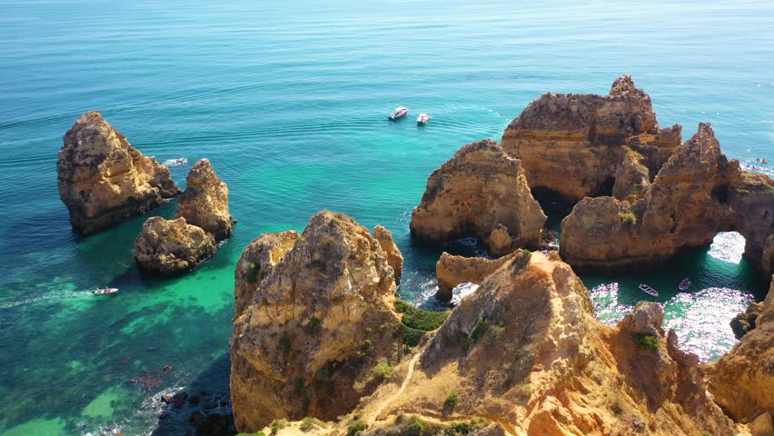Aerial 4K video from drone to Ponta da Piedade near Lagos in Algarve, Portugal. Tourist boats and cliff rocks in the Atlantic Ocean at Ponta da Piedade, Algarve region, Portugal.
