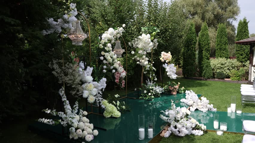 a wedding arch with chairs and flowers in the garden