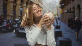 Young blonde woman smiling and kissing a piggy bank on urban street with taxi in background, showcasing city life and savings concept. - Powered by Shutterstock - Get 15% off with code: PIKWIZARD15