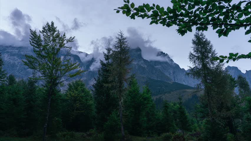 Timelapse of evening clouds moving over Austrian Alps mountain landscape