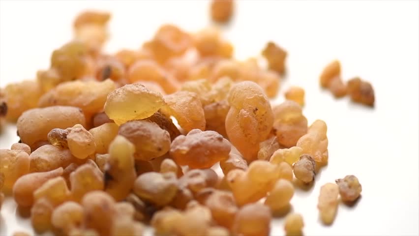 Frankincense olibanum resin, Boswellia sacra isolated on white background. Frankincense or olibanum aromatic resin used in incense and perfumes, fragrance, rotating backdrop, design, macro shot  