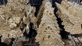Shiny gold christmas ornaments  angels, trees, snowflakes and baubles  glittering and hanging in a store display, festive holiday decor for seasonal celebrations and retail sale - Powered by Shutterstock - Get 15% off with code: PIKWIZARD15