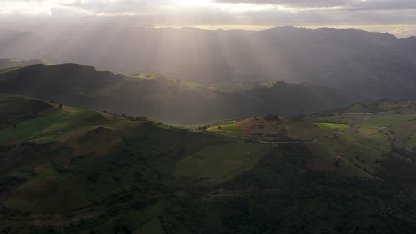Beautiful sunbeams illuminate the green, rolling hills and valleys of cantabria, spain, creating a breathtaking natural spectacle