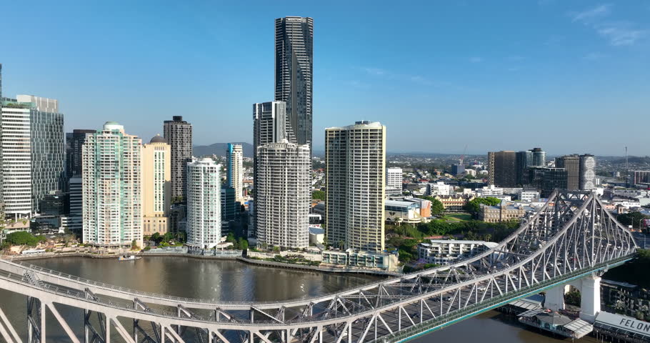 4K aerial pull out camera tracking view of the iconic Story Bridge and east side of Brisbane CBD with Brisbane River below where the CityCat ferries commute passengers, Brisbane, Queensland, Australia