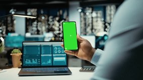 Black male consultant in office uses green screen on smartphone after hours, scheduling new meetings and planning the weekly agenda. Business management tasks for a company project. Camera A. - Powered by Shutterstock - Get 15% off with code: PIKWIZARD15