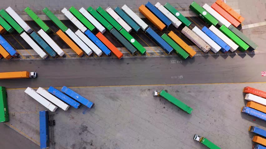 Top View of Orange Truck Leaving Parking Lot with Colorful Cargo Containers, October 7, 2025