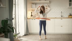 Young Asian woman enjoying a hula hoop exercise at home, wearing comfortable activewear. fun, energetic, and effective home workouts for weight loss, core strength, and a healthy lifestyle. - Powered by Shutterstock - Get 15% off with code: PIKWIZARD15
