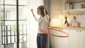 Young Asian woman enjoying a hula hoop exercise at home, wearing comfortable activewear. fun, energetic, and effective home workouts for weight loss, core strength, and a healthy lifestyle. - Powered by Shutterstock - Get 15% off with code: PIKWIZARD15