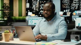 Black office employee checking a notification connected on socials while he does overtime at midnight, checking smartphone at work after hours. Young man reading text messages. Camera B. - Powered by Shutterstock - Get 15% off with code: PIKWIZARD15