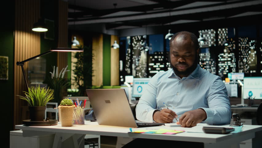 African american strategist ripping a paper after writing the wrong idea, restarting work in rage and crumpling the page sheet. Discontent man does a typo mistake while transcribing. Camera A.