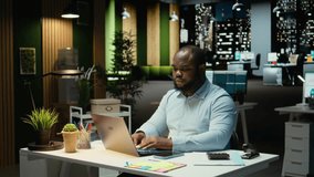 Black office employee checking a notification connected on socials while he does overtime at midnight, checking smartphone at work after hours. Young man reading text messages. Camera A. - Powered by Shutterstock - Get 15% off with code: PIKWIZARD15