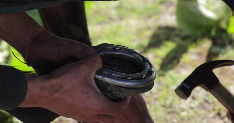 Tibetan people fitting a new horseshoe to a horse