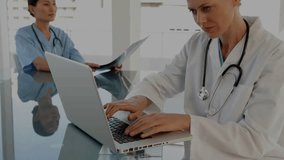 Doctor typing laptop while peer holding X-ray film floating finance charts cross-referencing data. Medical, technology, collaboration, innovation, analysis, healthcare, professionalism - Powered by Shutterstock - Get 15% off with code: PIKWIZARD15