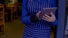 Bicycle repair shop manager in apron tapping tablet and swiping for visualizing network overlay. Technology, connectivity, digital, communication, workflow, workshop, professional - Powered by Shutterstock - Get 15% off with code: PIKWIZARD15